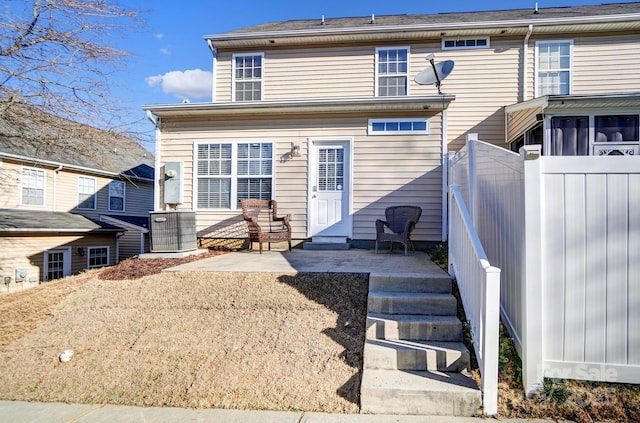 rear view of house with cooling unit, fence, and a patio