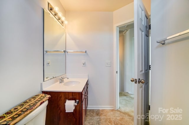 half bath with tile patterned flooring, vanity, toilet, and baseboards