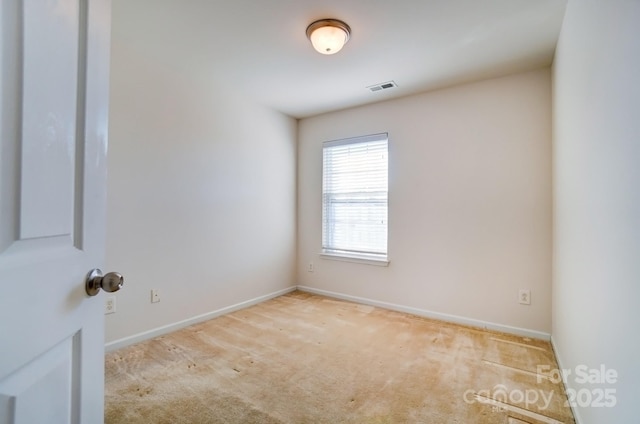 carpeted empty room with visible vents and baseboards