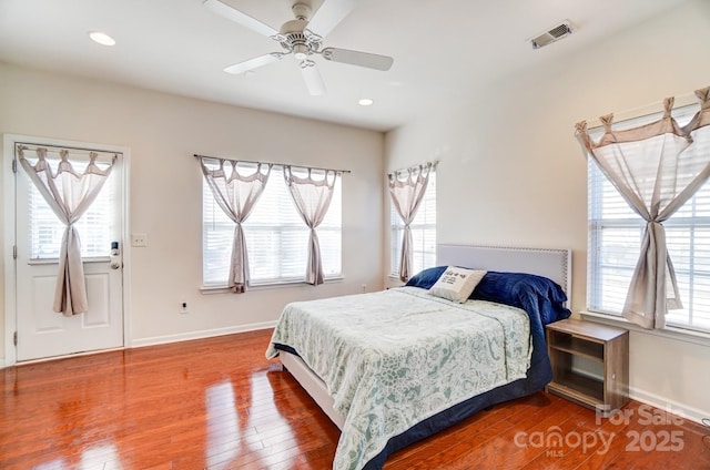 bedroom with visible vents, multiple windows, and hardwood / wood-style flooring