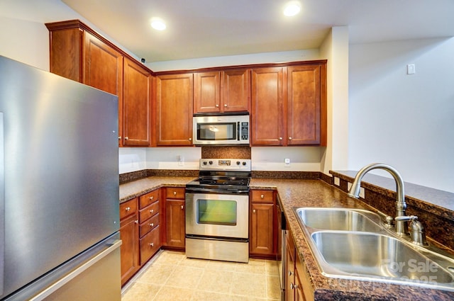 kitchen featuring light tile patterned floors, appliances with stainless steel finishes, a sink, and recessed lighting