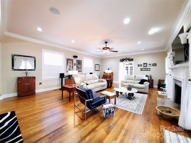 living room featuring baseboards, a fireplace with flush hearth, ornamental molding, and wood finished floors