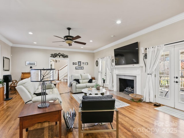 living area with stairway, wood finished floors, french doors, a fireplace, and recessed lighting