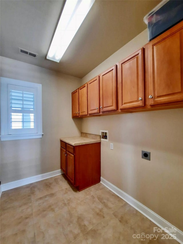 clothes washing area with hookup for a washing machine, hookup for an electric dryer, visible vents, baseboards, and cabinet space