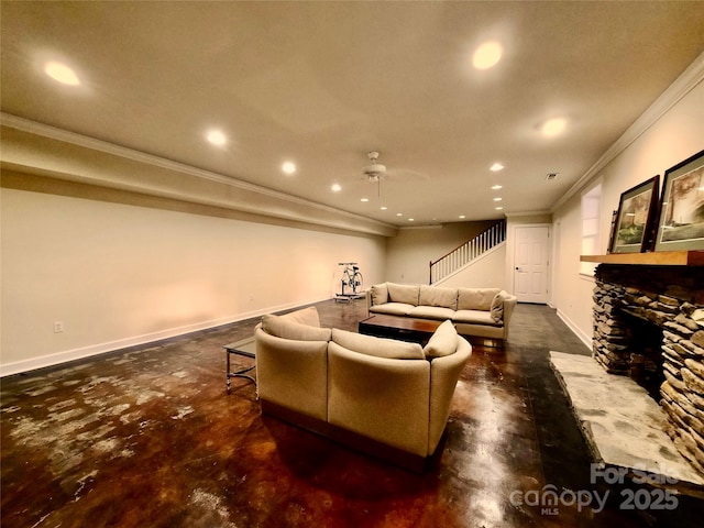 cinema with finished concrete flooring, baseboards, a ceiling fan, crown molding, and a stone fireplace