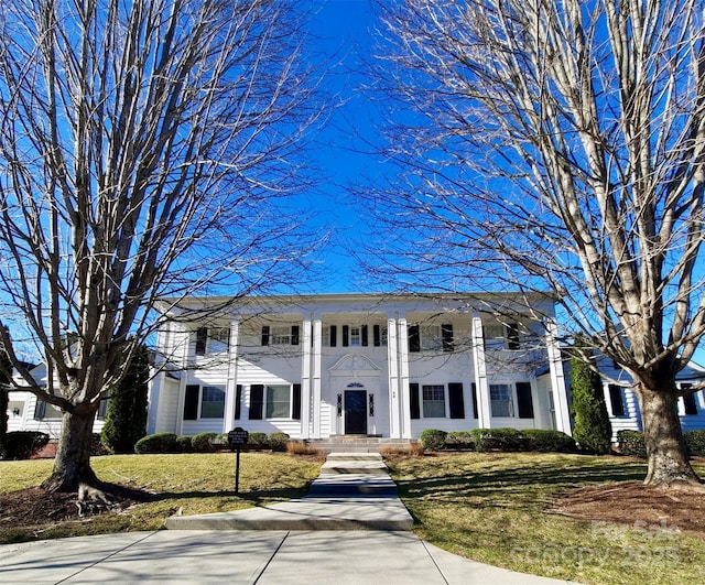 neoclassical home with a front yard