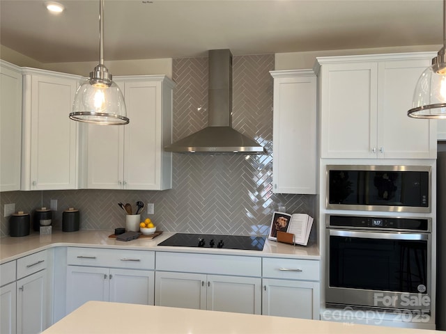 kitchen featuring tasteful backsplash, stainless steel oven, black electric cooktop, wall chimney range hood, and white cabinetry