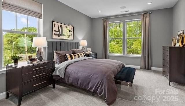 carpeted bedroom with multiple windows, visible vents, and baseboards