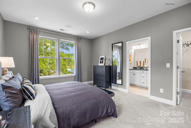 bedroom featuring light carpet, baseboards, a spacious closet, and visible vents