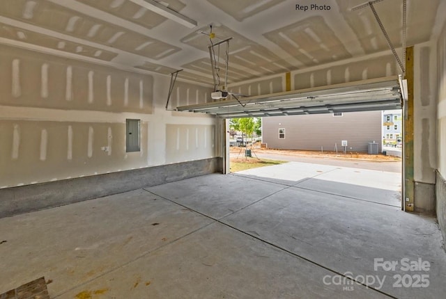 garage featuring a garage door opener, electric panel, and central AC