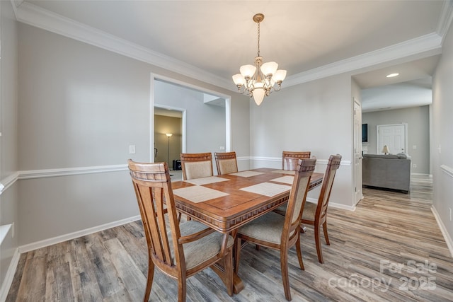 dining room with light wood-type flooring, baseboards, and a notable chandelier