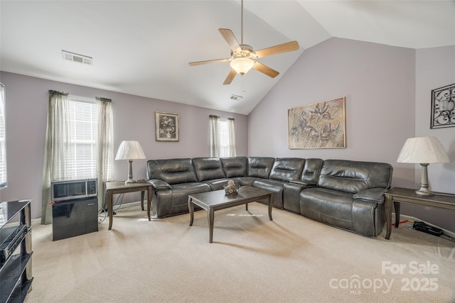 carpeted living area with lofted ceiling, ceiling fan, a wealth of natural light, and visible vents