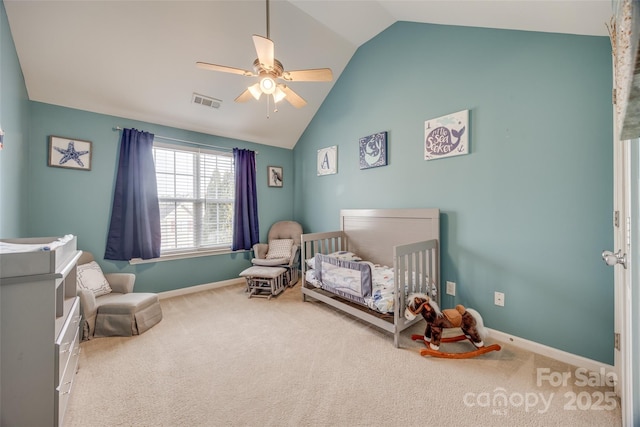 bedroom with lofted ceiling, visible vents, carpet flooring, and a crib