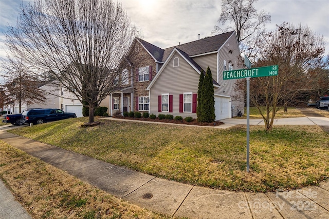 view of front of home featuring a garage, concrete driveway, and a front lawn