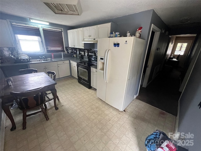 kitchen with black electric range oven, under cabinet range hood, light floors, white fridge with ice dispenser, and white cabinetry