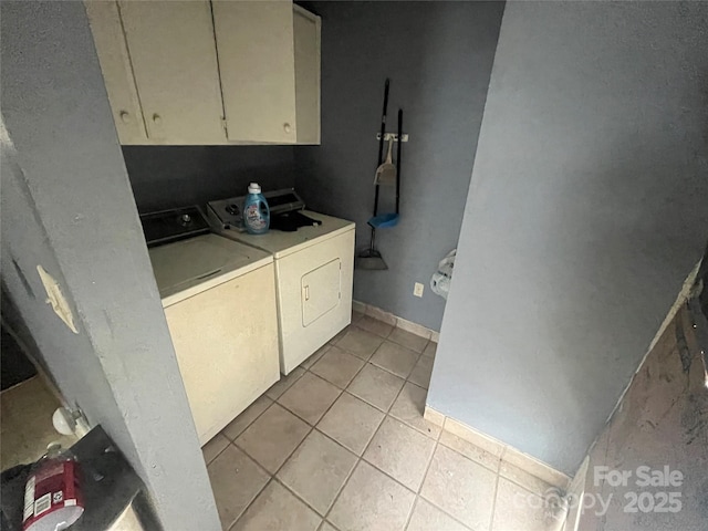 laundry area featuring cabinet space, baseboards, washer and dryer, and light tile patterned flooring