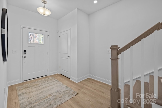 foyer with light wood-type flooring, stairway, baseboards, and recessed lighting