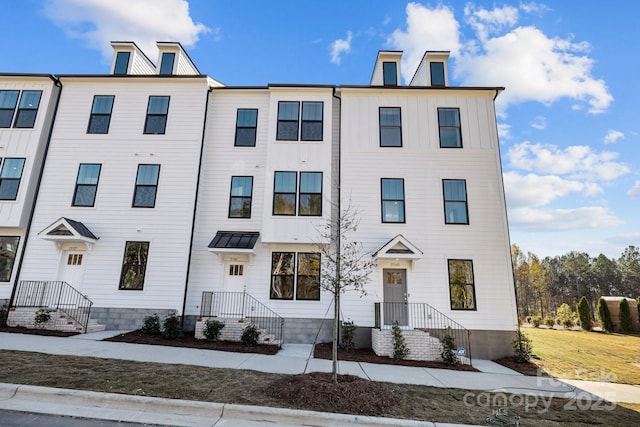 townhome / multi-family property featuring metal roof, board and batten siding, and a chimney