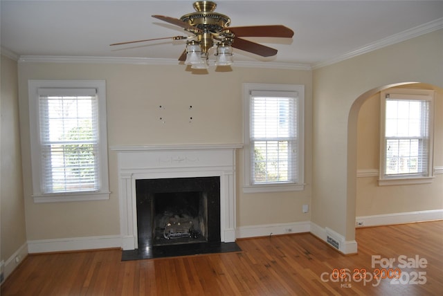 unfurnished living room featuring visible vents, a fireplace, ornamental molding, and wood finished floors