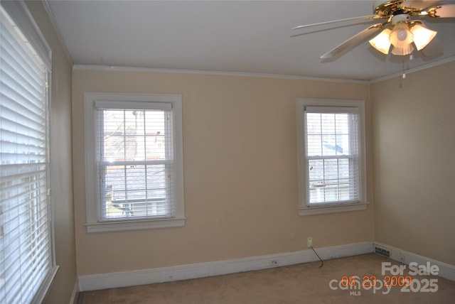 spare room featuring baseboards, carpet floors, ceiling fan, and crown molding