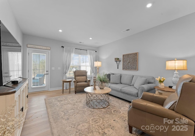 living area featuring light wood-style flooring, visible vents, baseboards, and recessed lighting