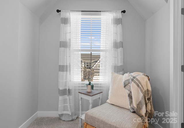 sitting room with baseboards, vaulted ceiling, and carpet flooring