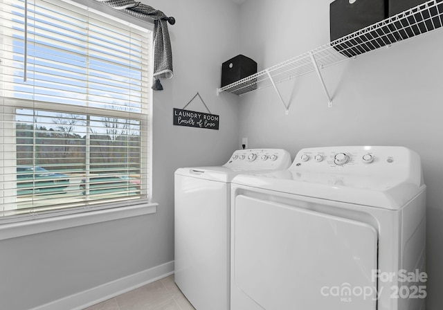 laundry area with light tile patterned floors, laundry area, washing machine and dryer, and baseboards