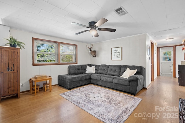 living room featuring a ceiling fan, a wealth of natural light, visible vents, and wood finished floors