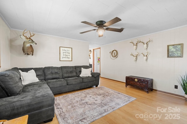 living room with crown molding, baseboards, ceiling fan, and wood finished floors