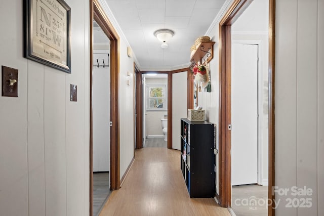 hall with crown molding and light wood-style flooring