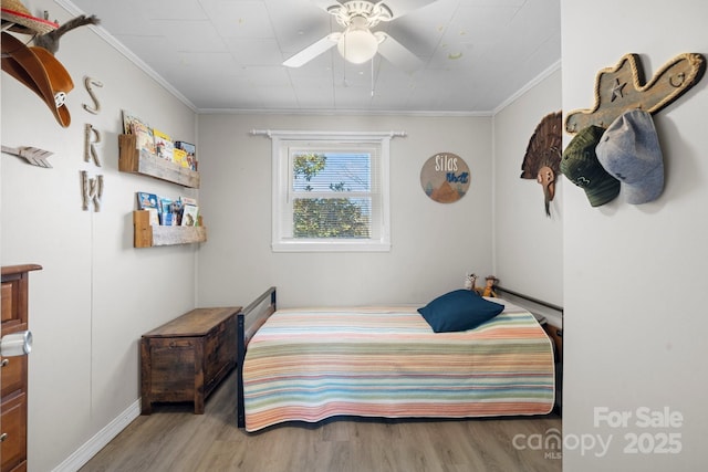 bedroom with ceiling fan, crown molding, and wood finished floors