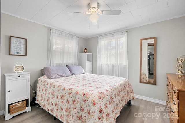 bedroom featuring light wood-style flooring and crown molding