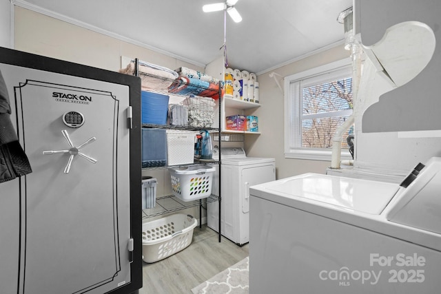 laundry room with light wood-type flooring, laundry area, separate washer and dryer, and crown molding