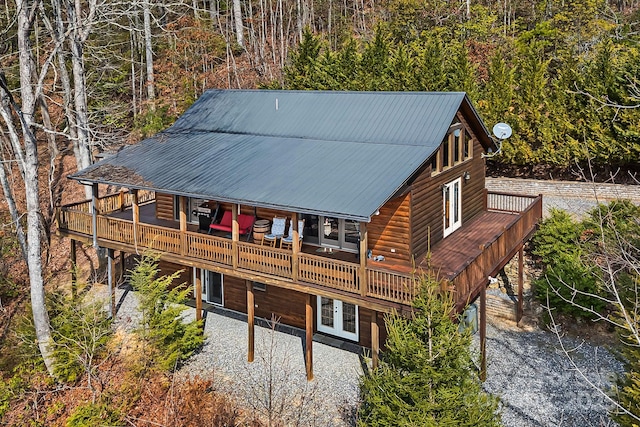 back of house featuring a deck, metal roof, and log veneer siding