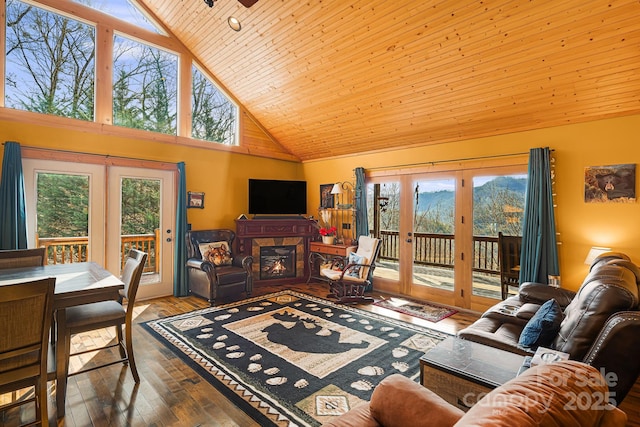 living area with a glass covered fireplace, hardwood / wood-style flooring, wood ceiling, french doors, and high vaulted ceiling