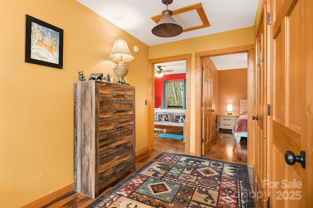 hallway featuring wood finished floors and baseboards