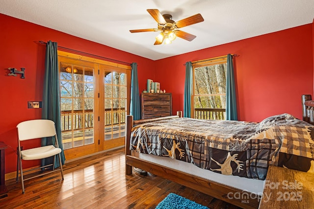 bedroom with hardwood / wood-style floors, a ceiling fan, and access to exterior