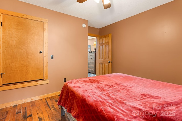 bedroom featuring ceiling fan, wood-type flooring, and baseboards