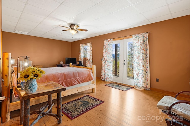 bedroom featuring a paneled ceiling, wood finished floors, visible vents, access to exterior, and french doors