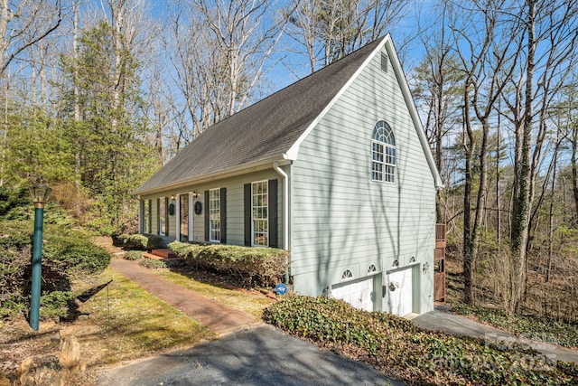 view of property exterior with driveway and an attached garage