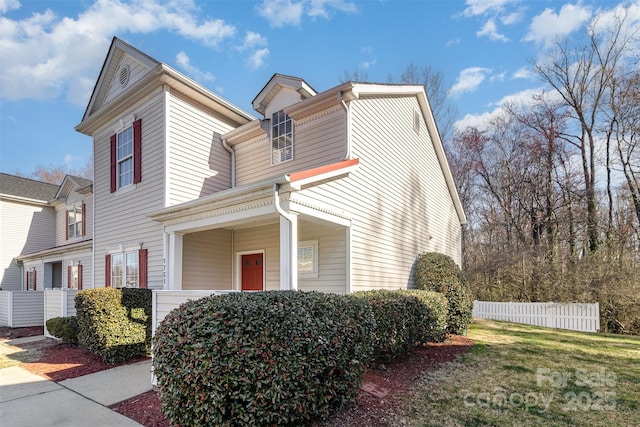 view of property exterior with a yard and fence