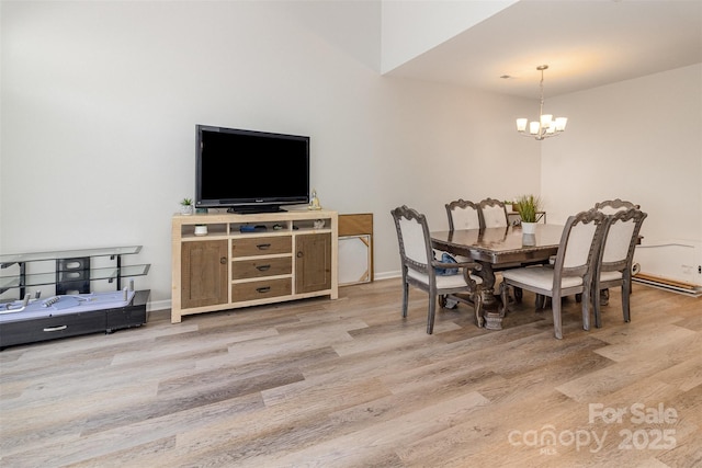 dining area featuring baseboards, light wood-type flooring, and an inviting chandelier