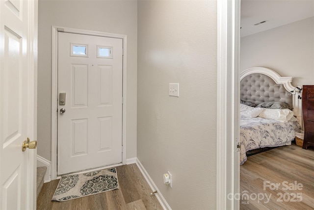 entryway featuring baseboards and wood finished floors