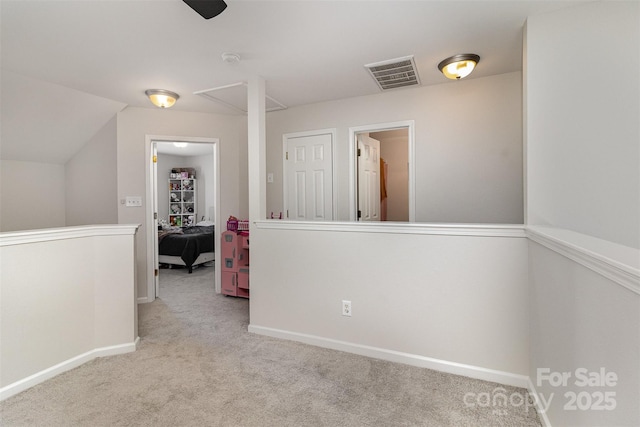 hallway featuring carpet, an upstairs landing, visible vents, and baseboards