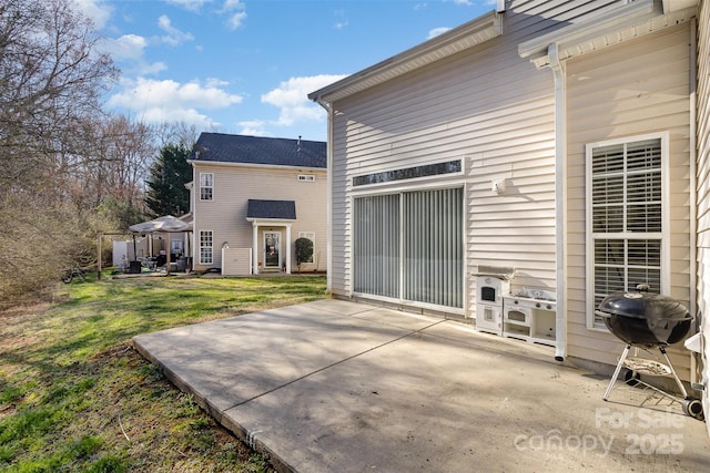 back of property featuring a garage, a patio area, a lawn, and concrete driveway