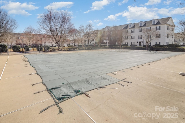 view of swimming pool with a patio area, fence, and a residential view