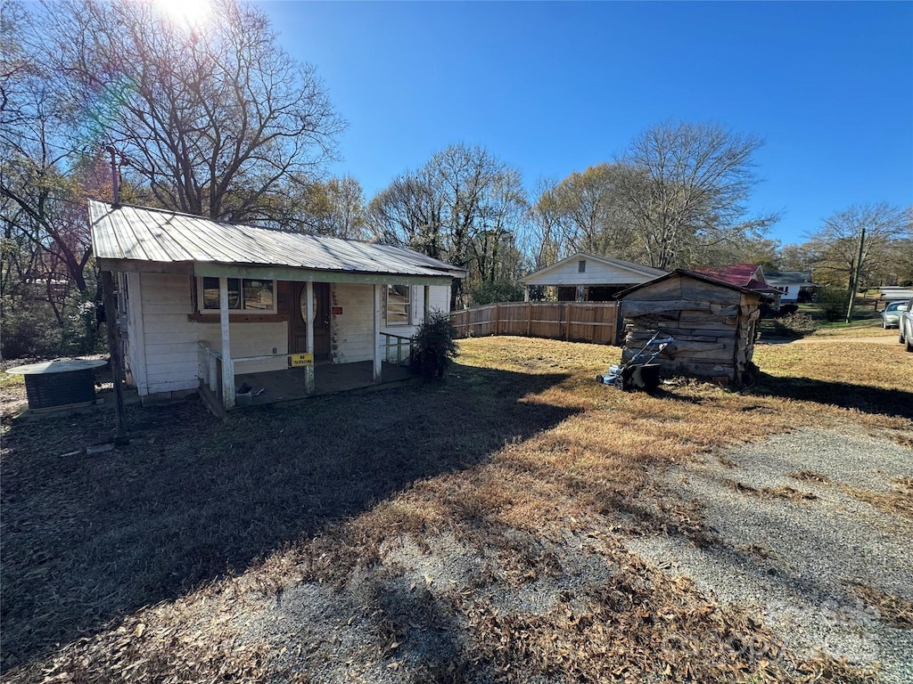 view of outbuilding featuring an outbuilding, fence, and central AC unit