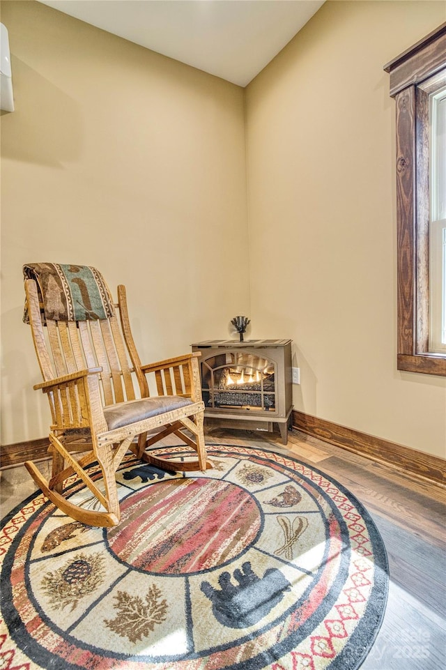 living area with baseboards and wood finished floors