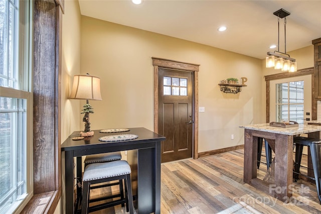 foyer featuring light wood finished floors, baseboards, a wealth of natural light, and recessed lighting