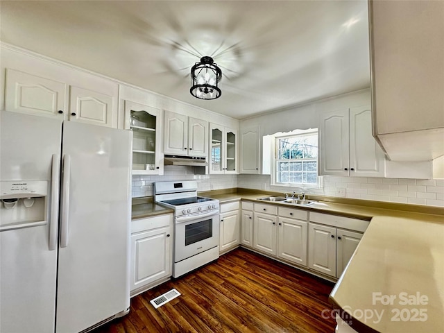 kitchen featuring dark wood finished floors, white cabinetry, a sink, white appliances, and under cabinet range hood